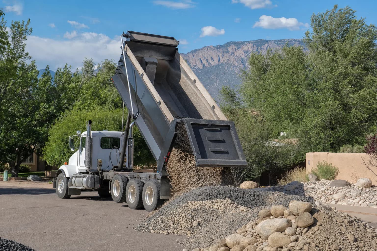 Dump truck delivering gravel to a residential property